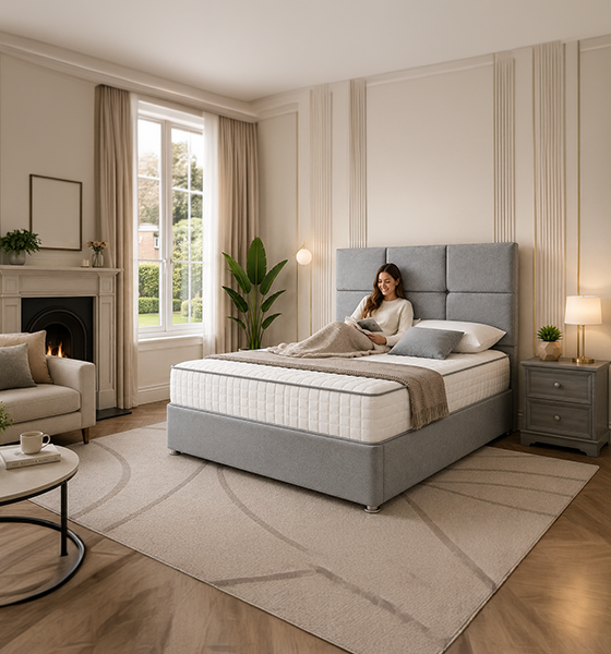 Grey upholstered bed with a person relaxing